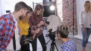 专业摄影工作室的摄影师工作室正在培训年轻的摄影师，在后台安装数码相机